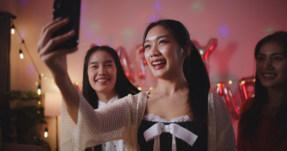 Selective focus, Beautiful woman use smartphone making video call during has celebrate the New Year's party with girl gang, happiness and enjoy togetherness.