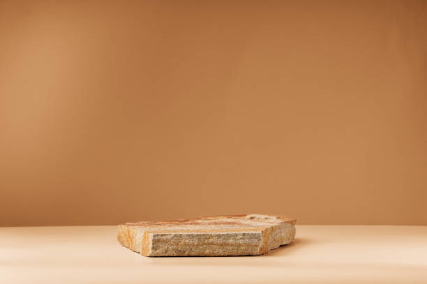 istock Piece of granite stone against beige background with shadows 1888911113