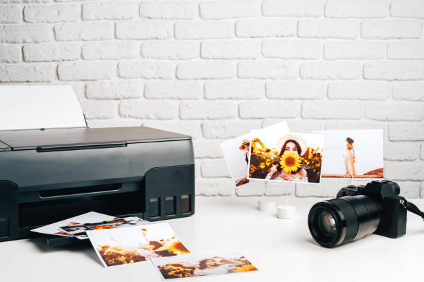 istock Printer and photo camera on table. Printing photos concept 1888915826