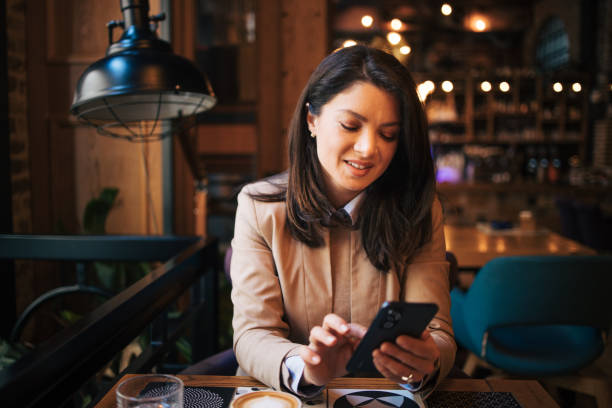 istock Young woman in cafe drinking coffee and texting 1888925156