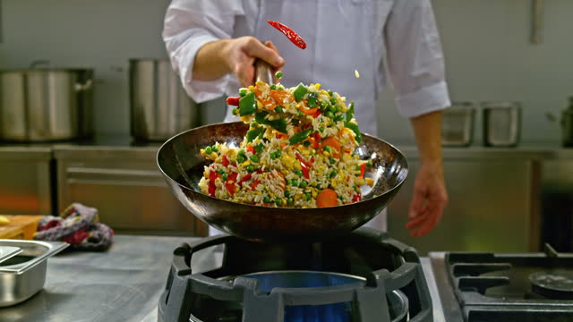 SLO MO DS Chef tossing a fried rice dish in a wok