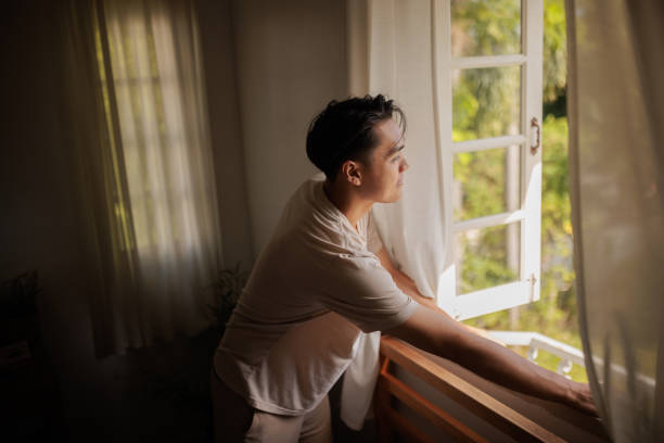 Man looking through window in the morning