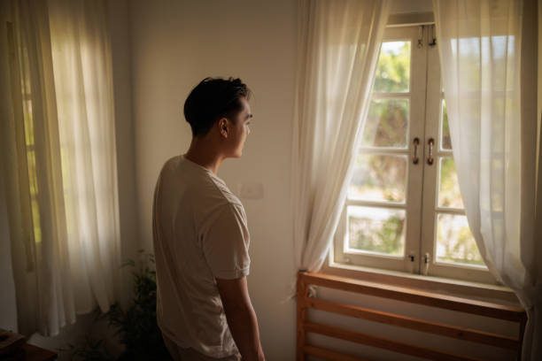istock Young Asian man by the window 1888969053