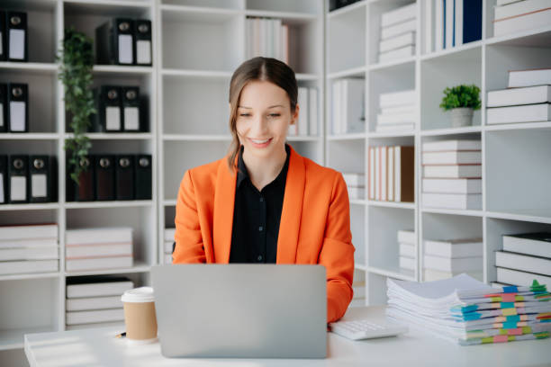 istock Beautiful woman using laptop and tablet while sitting at her working place. Concentrated at work. 1888971116