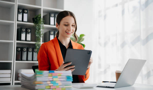 istock Beautiful woman using laptop and tablet while sitting at her working place. Concentrated at work. 1888971121