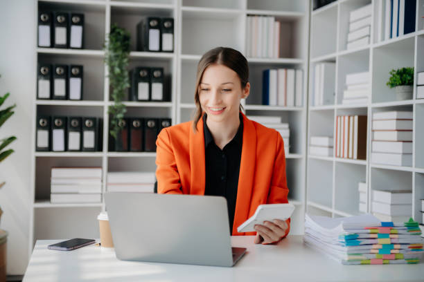 istock Beautiful woman using laptop and tablet while sitting at her working place. Concentrated at work. 1888971124