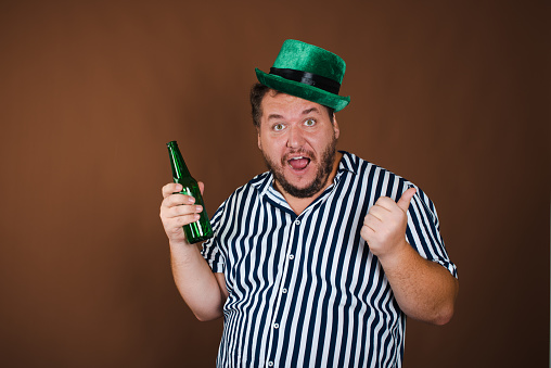 A man wearing a st patrick hat and sunglasses. St.Patrick 's Day. Festive party. Leisure activities by people in the forest. Nature. Picnic. Background image. Place for your text.