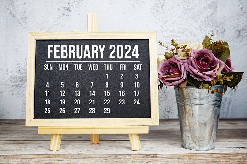 February 2024 monthly calendar with flower bouquet decoration on wooden background