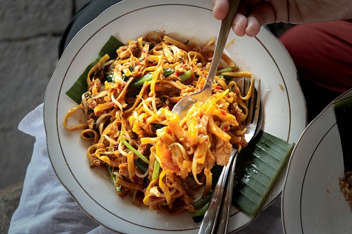 Javanese Fried Noodles or Javanese noodles or Javanese noodles with spoon and fork. Traditional Indonesian street food noodles from Central Java or Yogyakarta.