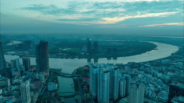 Forwards fly above modern metropolis with illuminated skyscrapers and busy highway. Beautiful hyperlapse footage of sunrise. Saigon River Tunnel Hochiminh City, Vietnam stock video.