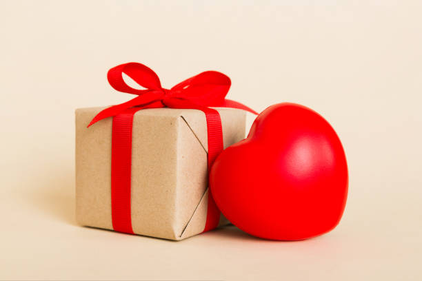 istock gift box with red bow and red heart on colored background. Perspective view. Flat lay 1889067897