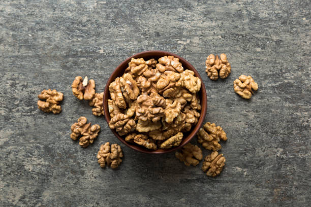 istock Fresh healthy walnuts in bowl on colored table background. Top view Healthy eating bertholletia concept. Super foods 1889067916