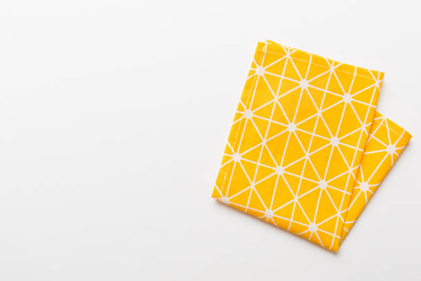 top view with yellow empty kitchen napkin isolated on table background. Folded cloth for mockup with copy space, Flat lay. Minimal style