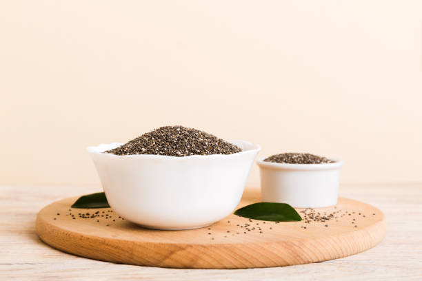 Chia seeds in bowl on colored background. Healthy Salvia hispanica in small bowl. Healthy superfood Chia seeds in bowl on colored background. Healthy Salvia hispanica in small bowl. Healthy superfood. salvia hispanica plant stock pictures, royalty-free photos & images