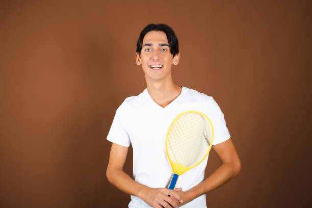 A male tennis player with a ball on a tennis racket