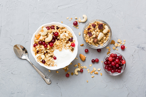 Oatmeal with yogurt, almonds and pomegranate in a bowl standing on a table