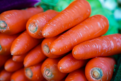 Picture of fresh carrots stacked on a vegetable table at a fresh market, Chiang Mai, Thailand.