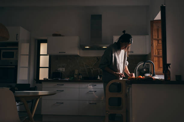 istock Woman cutting fruits while cooking in kitchen 1889135078