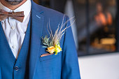 Detail of the groom's suit at the wedding with some beautiful flowers in the pocket