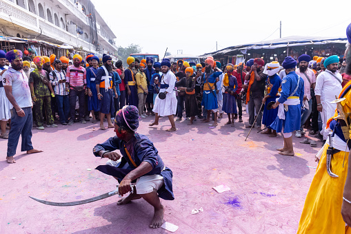 Anandpur Sahib, Punjab, India - March 2022: Portrait of sikh male (Nihang Sardar) performing martial art as culture during the celebration of Hola Mohalla at Anandpur Sahib during holi festival.