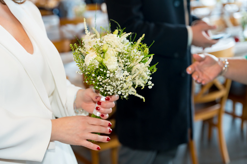 the bride holds a pink wedding bouquet in her hand