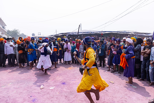 Anandpur Sahib, Punjab, India - March 2022: Portrait of sikh male (Nihang Sardar) performing martial art as culture during the celebration of Hola Mohalla at Anandpur Sahib during holi festival.