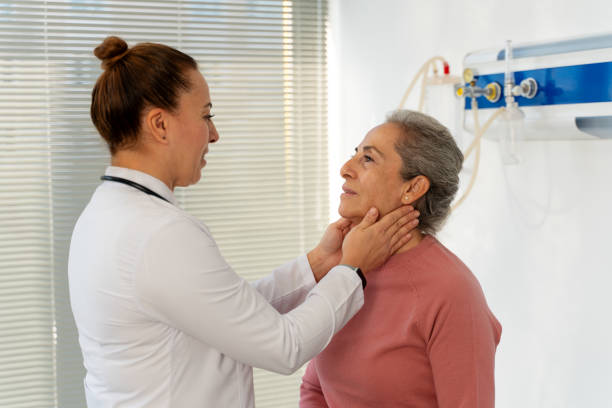 istock Doctor checking senior woman's lymph nodes in doctor´s office 1889158630