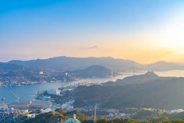 Photo of Nagasaki cityscape panorama view from Mt Inasa observation platform deck in sunny day sunset time