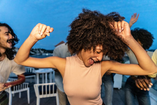 Young woman dancing with her friends on the rooftop