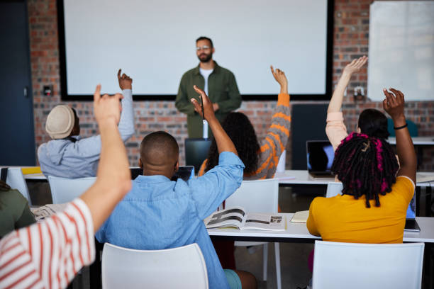 istock Students raising their hands to ask their teacher questions during a college class 1889232029
