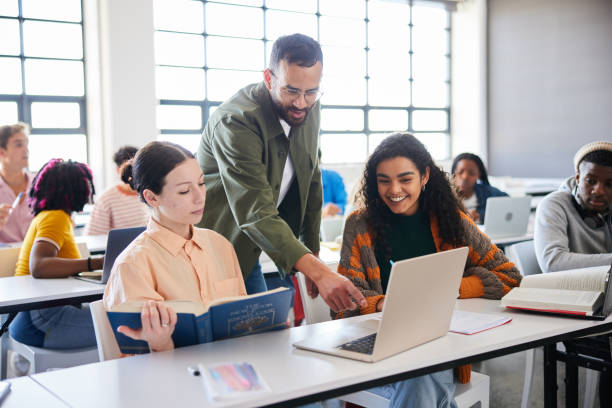 istock Teacher helping a two female students during a class at college 1889237008