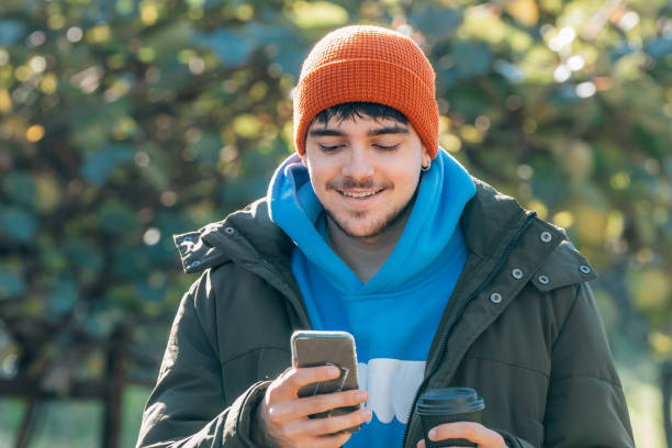 istock young man bundled up in winter outdoors with mobile phone 1889245854