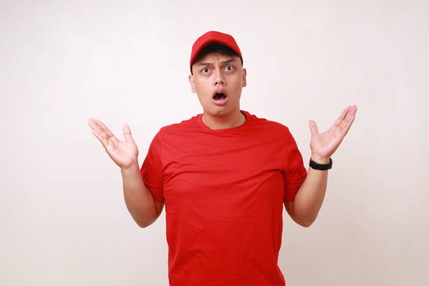 istock Confused Handsome young asian courier standing with question hand gesture and expression against white background 1889259071