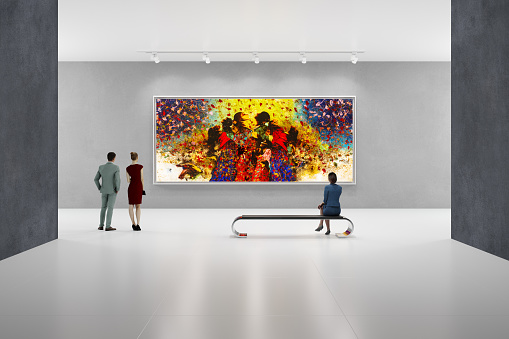In an art center, visitors looks at the artist's modern art collection. Modern colorful paintings on exhibition.