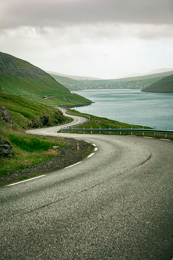 winding coastal road through the fjords of the faeroe islands, north atlantic islands, denmark, europe.