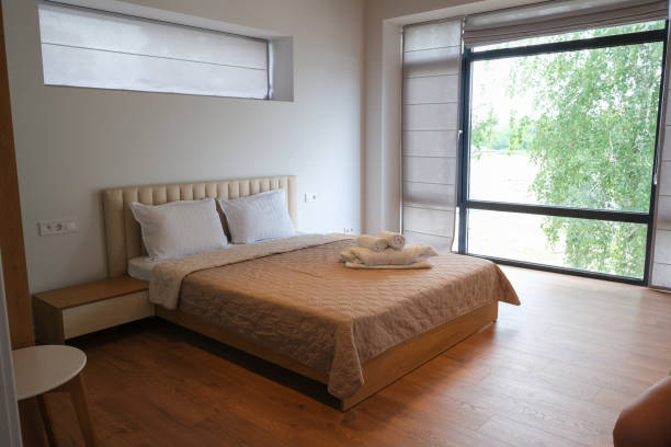 istock A cozy double bed in a lounge room with a large window. 1889324793
