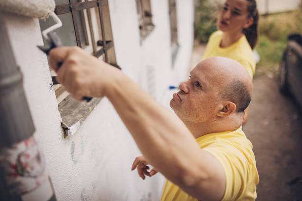 istock Volunteers renovating wall together 1889326966