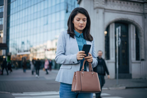 istock Young brunette woman using a smartphone at the street 1889341264