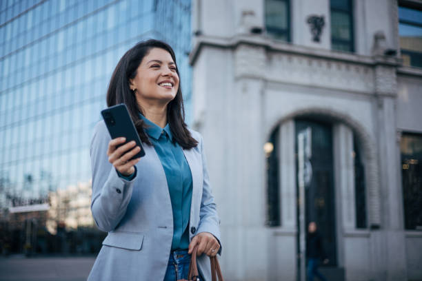 istock Young brunette woman using a smartphone at the street 1889344956