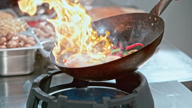 SLO MO Shrimp and vegetables being tossed in a heated wok