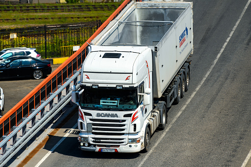 seaport, Odessa, Ukraine, May 4, 2019 - truck transports container through industrial seaport, warehouses with containers, a logistics hub for international transportation by trucks and ships