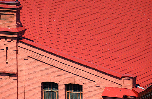 seaport, Odessa, Ukraine, May 4, 2019 - the facade of an old industrial building, brick walls painted red, red roof, wooden door for the entrance to the building