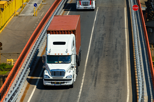 seaport, Odessa, Ukraine, May 4, 2019 - truck transports container through industrial seaport, warehouses with containers, a logistics hub for international transportation by trucks and ships