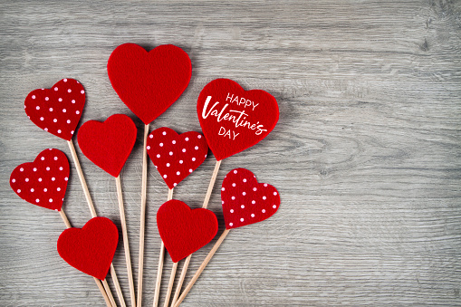 Happy Valentine’s day concept with felt hearts on wooden backgorund