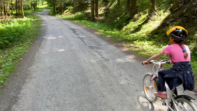 Small girl riding  bicycle on the mountain route
