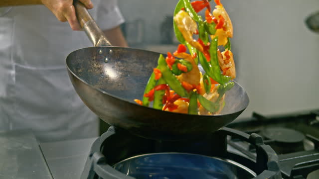 SLO MO DS Chef tossing the prawns and veggies frying in the hot wok