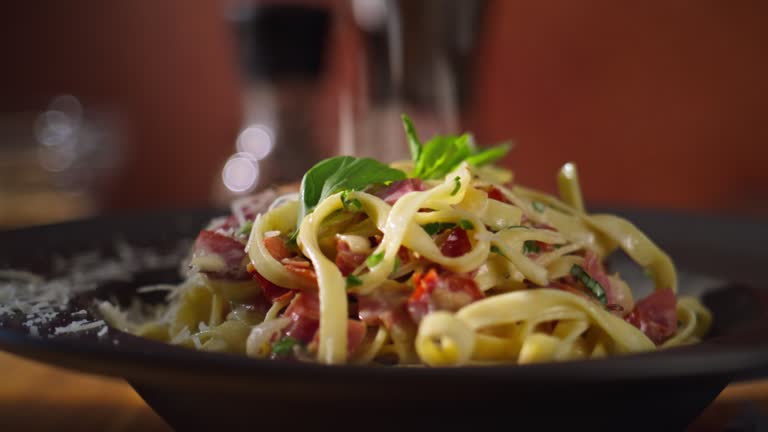 DS Grated cheese falling onto a plate of a pasta dish