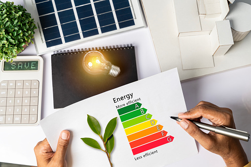 House Energy Audit. Energy efficiency concept with level chart Tabletop energy efficiency graph with house diagram calculator Solar panels. Businessman planning to use energy.