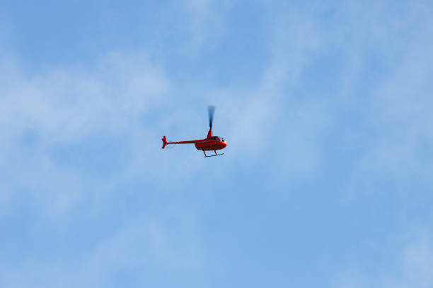 istock Small red civil helicopeter is in hlue sky 1889428275