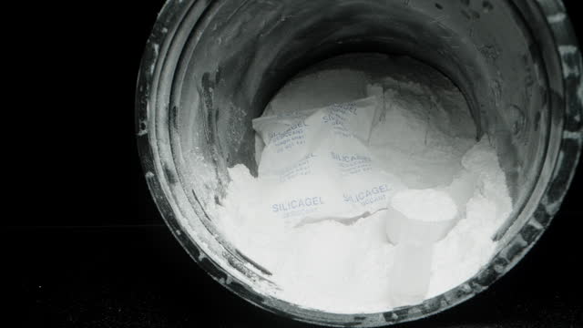 Packet With Silica Gel In A Jar With White Powder Of Creatine. Desiccant Indicates That It Is Not For Food. Dolly slider, close up.